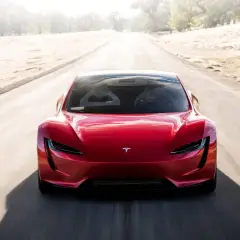 Roter Tesla Roadster rast auf einer leeren Straße, bereit für den Tesla Roadster 0-100 Sprint.