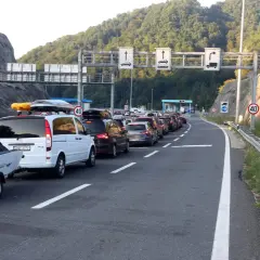 Langer Stau in Slowenien an der Mautstelle. Autos mit Dachboxen und Anhängern warten auf der Autobahn.