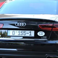Schwarzer Audi A6 mit dem Kennzeichen "D 0 155-1" und dem ovalen Aufkleber "CD". Dieses diplomaten Kennzeichen deutet auf eine besondere Funktion des Fahrzeugs hin.