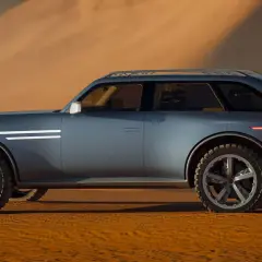 Ein futuristisches SUV der Automarke mit G, das durch eine Wüstenlandschaft fährt.
