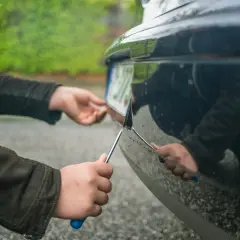 Person entfernt Kennzeichen. Fahren ohne Kennzeichen Strafe ist hoch.