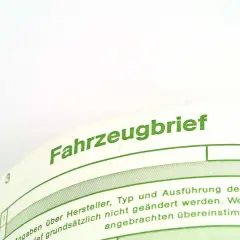 Fahrzeugbrief mit grüner Schrift. Hier steht, was bedeutet ABE: Allgemeine Betriebserlaubnis, die für das Fahrzeug gilt.