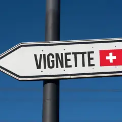Wegweiser mit "Vignette" und Schweizer Flagge. Hier beginnt die Schweiz, ohne Vignette geht es nicht weiter.