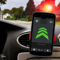 Smartphone mit Blitzer-App für Android Auto zeigt 50 km/h. Im Hintergrund rote Ampel und Häuser.
