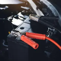 Starthilfe für das Auto: Rote und schwarze Klemmen sind an der Autobatterie befestigt, um sie wieder zum Leben zu erwecken.
