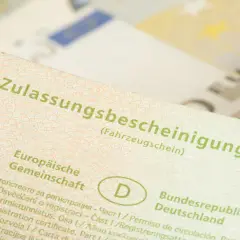 Zulassungsbescheinigung Teil I, die Kosten für die auto abmelden sind hier nicht ersichtlich. Euro-Scheine im Hintergrund.