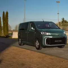 Ein grüner Van, der Toyota Proace Verso, fährt auf einer Straße. Dieses Van-Auto ist perfekt für Familienausflüge.