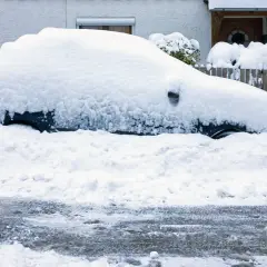 Auto komplett zugeschneit, der Motor muss laufen gelassen werden, um es freizubekommen.