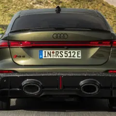 Ein Audi RS5 mit markantem Diffusor und ovalen Auspuffendrohren fährt auf einer kurvigen Straße.