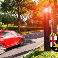 Roter Wagen rast vorbei an einem Blitzer im Rahmen des blitzermarathon rlp. Das Wappen von Rheinland-Pfalz ist zu sehen.