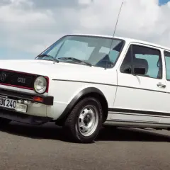 Weißer VW Golf GTI mit roten Akzenten und sportlicher Linienführung, der die Leistung des Motors unterstreicht.