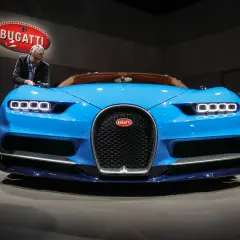 Blauer Bugatti Chiron, bereit für den 0-400 km/h Rekord. Ein Mann inspiziert das Meisterwerk.