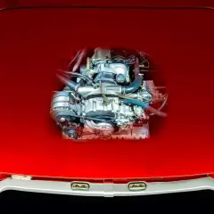 Ein Wankelmotor, das Herzstück eines besonderen Autos, glänzt unter der roten Motorhaube.