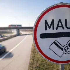 Mautschild an der belgischen Autobahn. Autos fahren schnell vorbei, bereit zur Bezahlung der Maut.