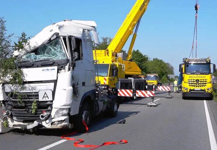Unfall auf der A30: Ein schwer beschädigter LKW wird von einem Kran geborgen. Ein Abschleppdienst ist vor Ort.