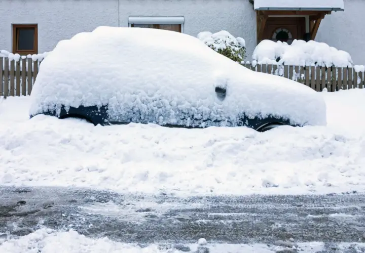Auto komplett zugeschneit, der Motor muss laufen gelassen werden, um es freizubekommen.