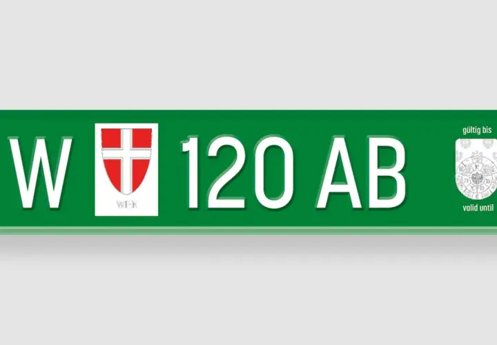 Grünes Wiener Kennzeichen "W 120 AB" mit Wappen und Prüfplakette.