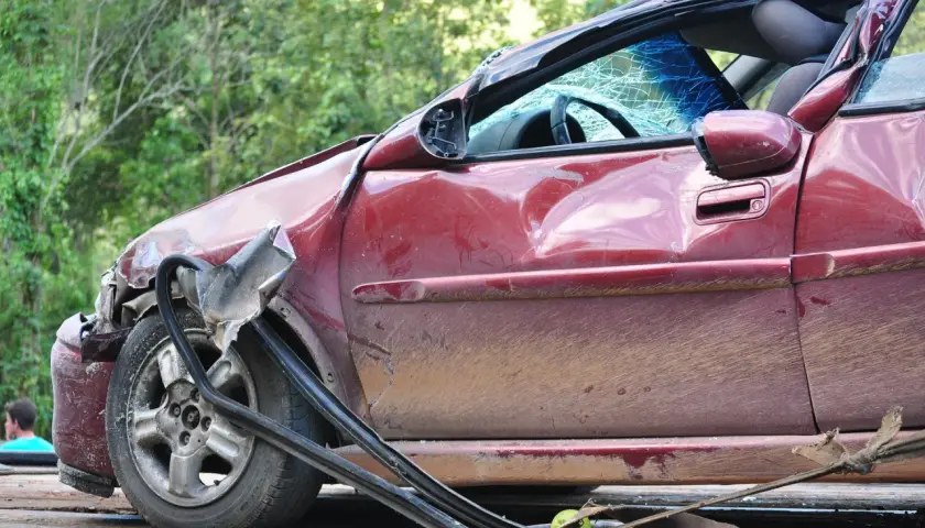 Schwer beschädigter roter Wagen, Windschutzscheibe zerbrochen. Ein trauriges Zeugnis eines Unfalls, vielleicht durch Alkohol verursacht.