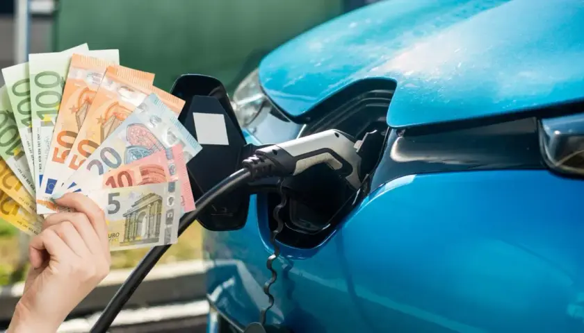 Blaue Elektroauto-Ladebuchse mit Euro-Scheinen. Die Formel für den Verbrauch pro 100 km wird durch die Kosten beeinflusst.