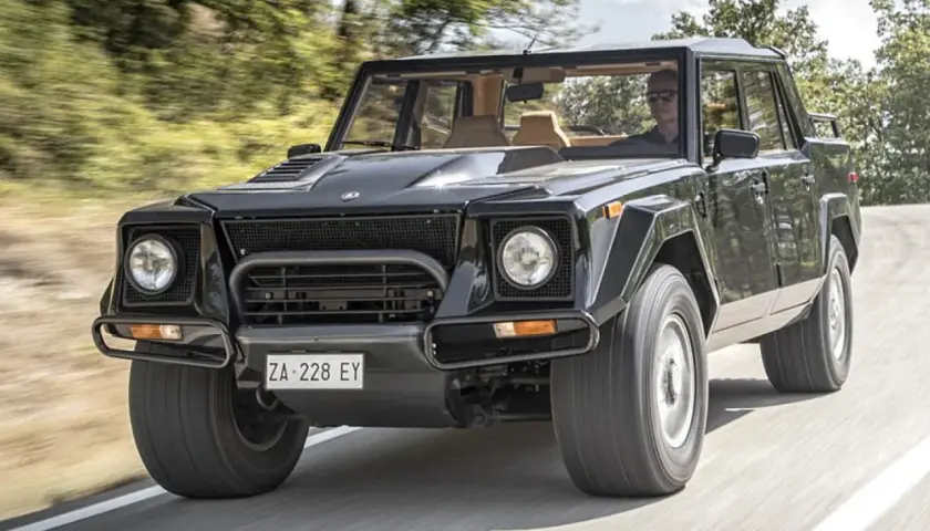 Schwarzer Lamborghini LM002 rast auf einer Straße. Der "Rambo Lambo" ist bekannt für seinen hohen Verbrauch.