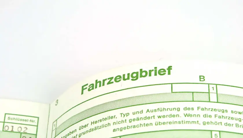 Fahrzeugbrief mit grüner Schrift. Hier steht, was bedeutet ABE: Allgemeine Betriebserlaubnis, die für das Fahrzeug gilt.
