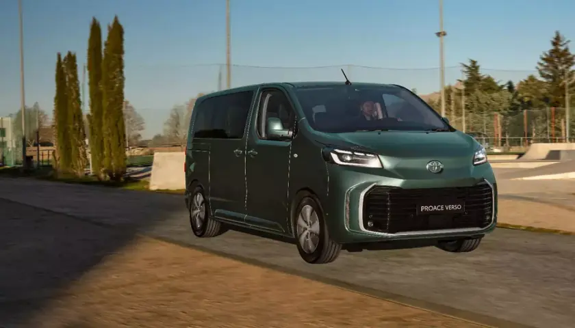 Ein grüner Van, der Toyota Proace Verso, fährt auf einer Straße. Dieses Van-Auto ist perfekt für Familienausflüge.