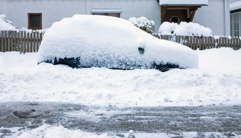 Auto komplett zugeschneit, der Motor muss laufen gelassen werden, um es freizubekommen.