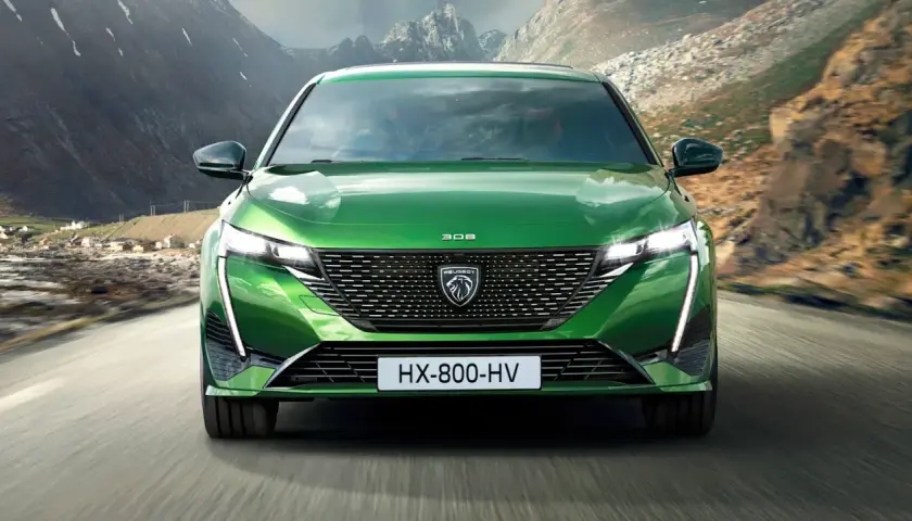 Grüner Peugeot 308 fährt auf einer Bergstraße. Breite Autos wie dieses bieten viel Platz und Komfort.