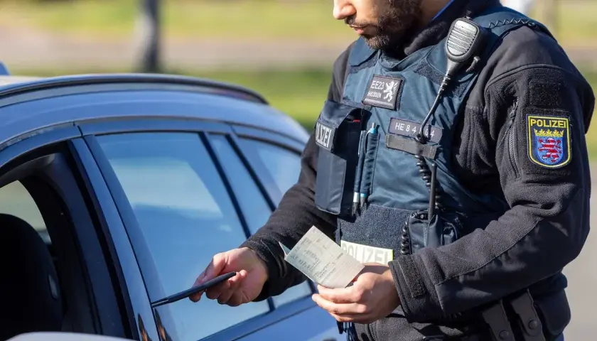 Polizist in Hessen kontrolliert Fahrzeugpapiere während des Blitzermarathons.