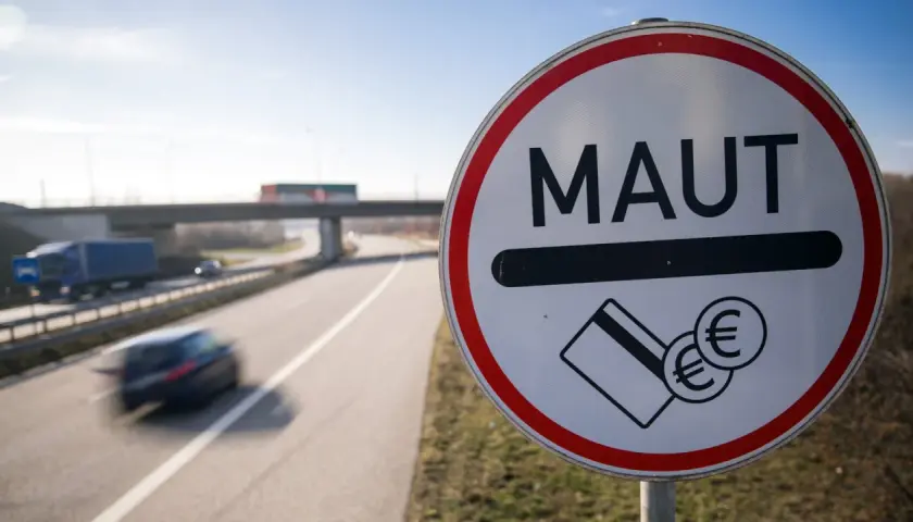 Mautschild an der belgischen Autobahn. Autos fahren schnell vorbei, bereit zur Bezahlung der Maut.