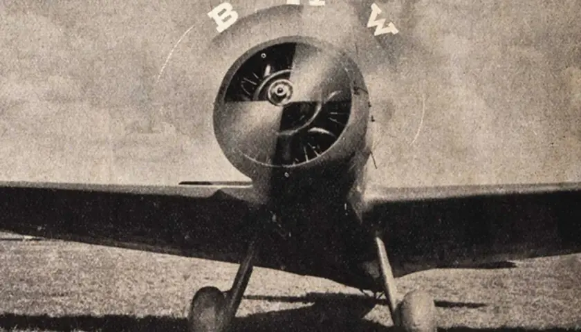 Ein altes Flugzeug mit dem BMW-Logo. Die Buchstaben B, M, W sind über dem Propeller angeordnet, was die BMW Logo Bedeutung unterstreicht.