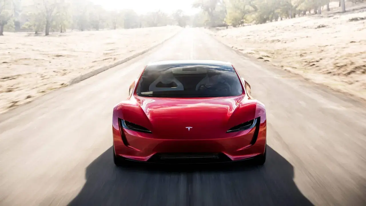 Roter Tesla Roadster rast auf einer leeren Straße, bereit für den Tesla Roadster 0-100 Sprint.
