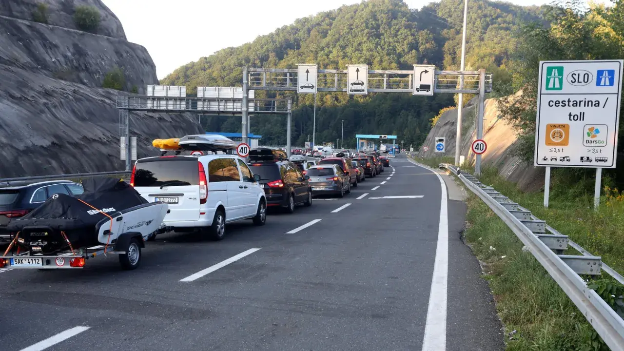Langer Stau in Slowenien an der Mautstelle. Autos mit Dachboxen und Anhängern warten auf der Autobahn.