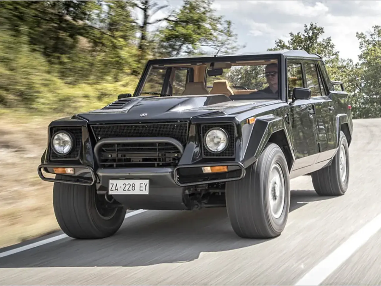 Schwarzer Lamborghini LM002 rast auf einer Straße. Der "Rambo Lambo" ist bekannt für seinen hohen Verbrauch.