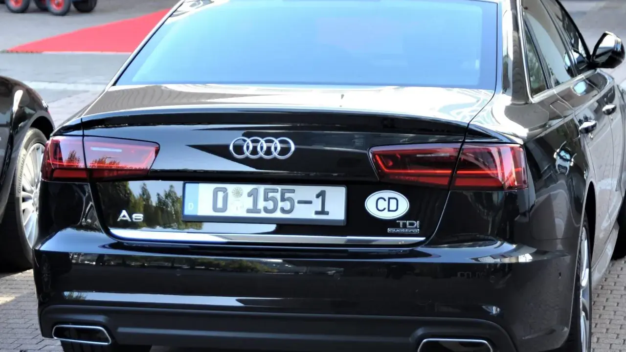 Schwarzer Audi A6 mit dem Kennzeichen "D 0 155-1" und dem ovalen Aufkleber "CD". Dieses diplomaten Kennzeichen deutet auf eine besondere Funktion des Fahrzeugs hin.