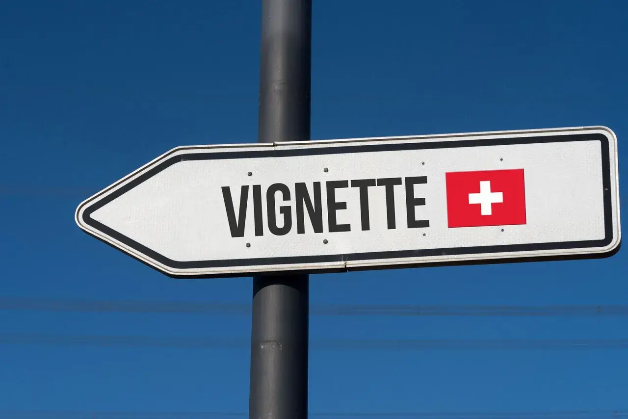 Wegweiser mit "Vignette" und Schweizer Flagge. Hier beginnt die Schweiz, ohne Vignette geht es nicht weiter.