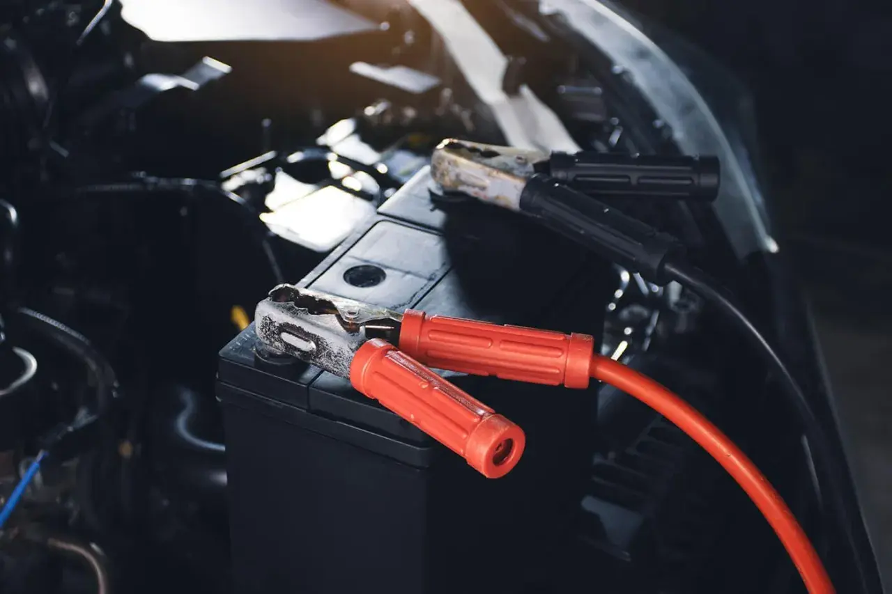 Starthilfe für das Auto: Rote und schwarze Klemmen sind an der Autobatterie befestigt, um sie wieder zum Leben zu erwecken.