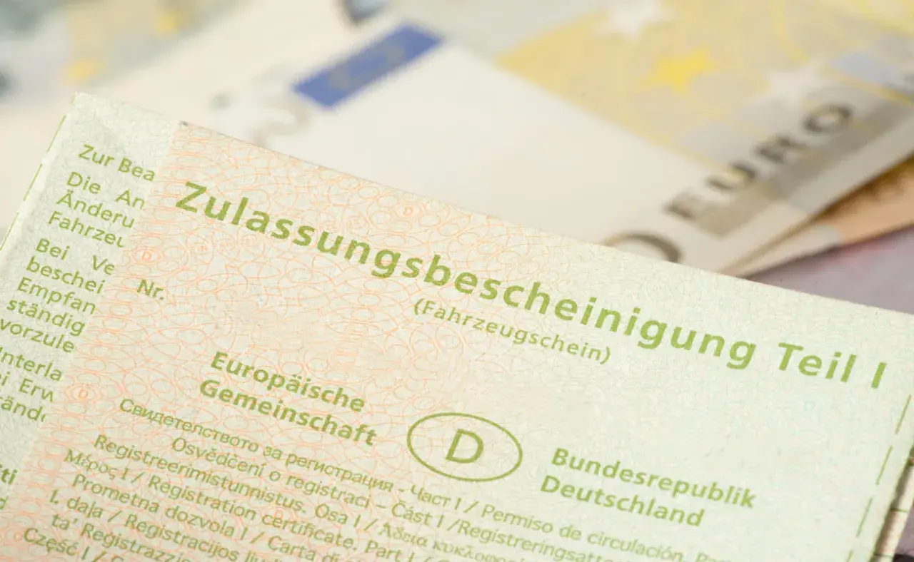 Zulassungsbescheinigung Teil I, die Kosten für die auto abmelden sind hier nicht ersichtlich. Euro-Scheine im Hintergrund.