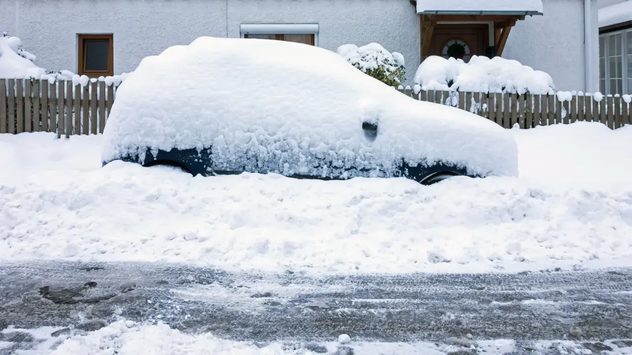 Auto komplett zugeschneit, der Motor muss laufen gelassen werden, um es freizubekommen.