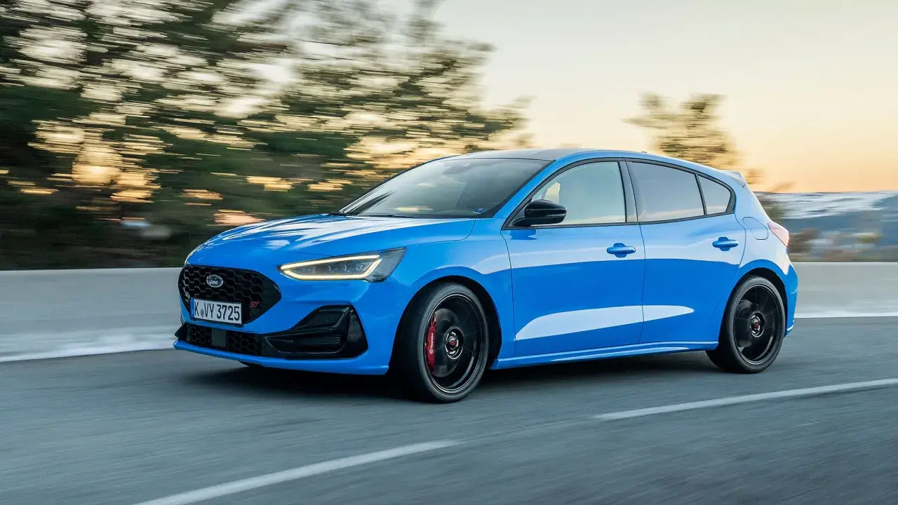 Ein blauer Ford Focus ST fährt auf einer Straße, die Bäume verschwimmen im Hintergrund.