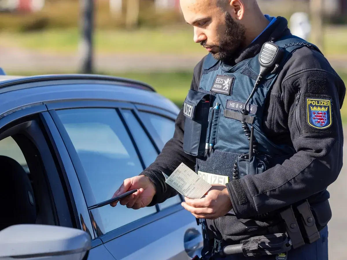 Polizist in Hessen kontrolliert Fahrzeugpapiere während des Blitzermarathons.