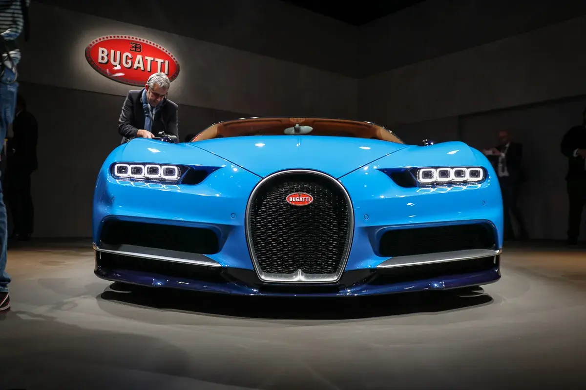 Blauer Bugatti Chiron, bereit für den 0-400 km/h Rekord. Ein Mann inspiziert das Meisterwerk.