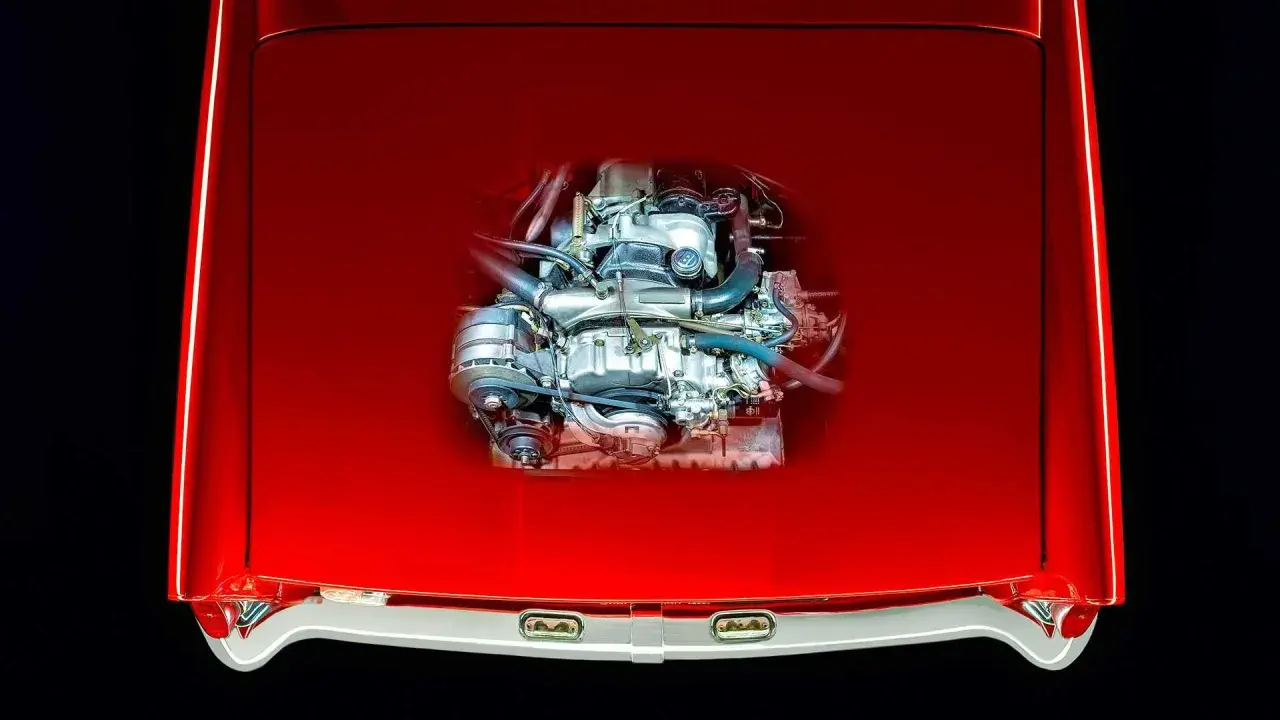 Ein Wankelmotor, das Herzstück eines besonderen Autos, glänzt unter der roten Motorhaube.
