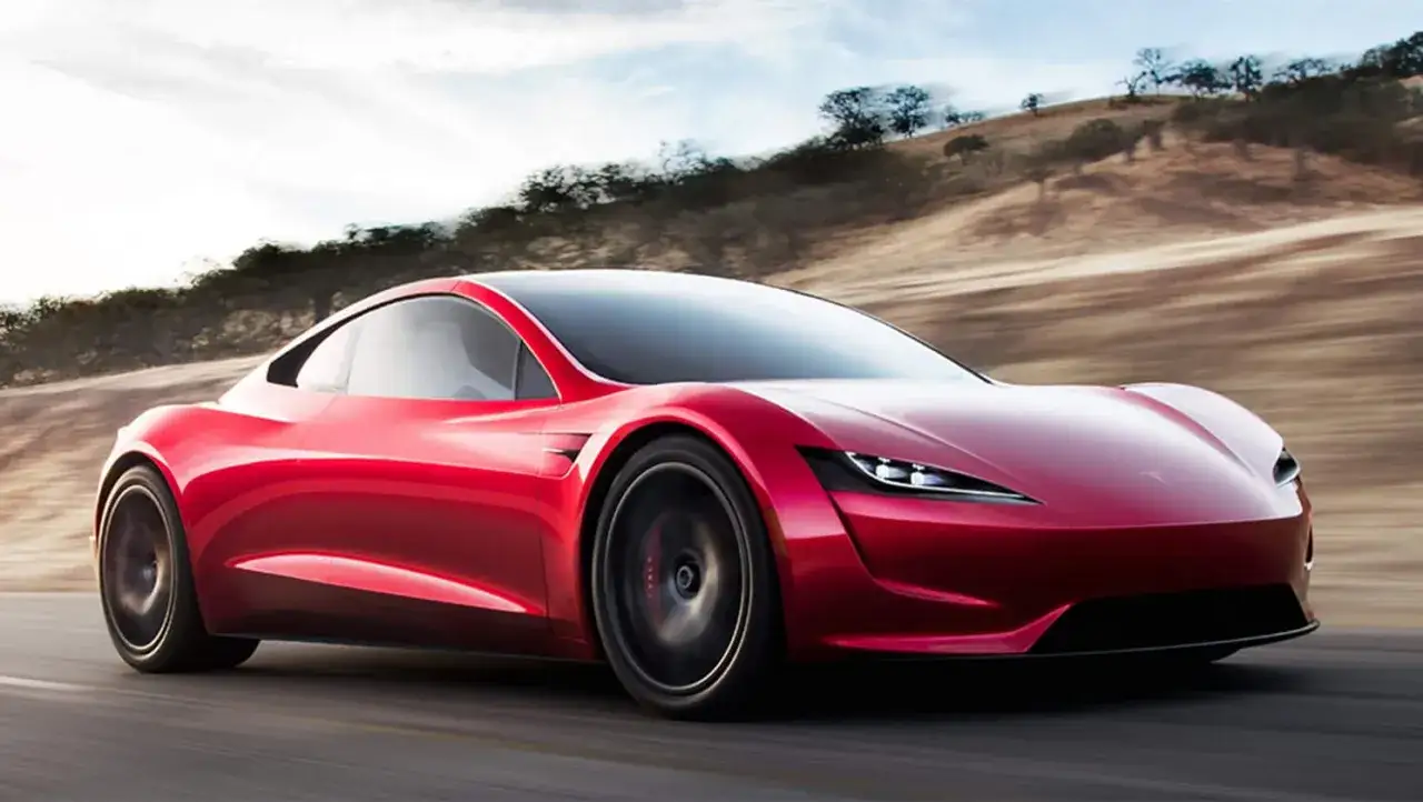 Roter Tesla Roadster rast über eine Straße, bereit für den unglaublichen Tesla Roadster 0-100 Sprint.