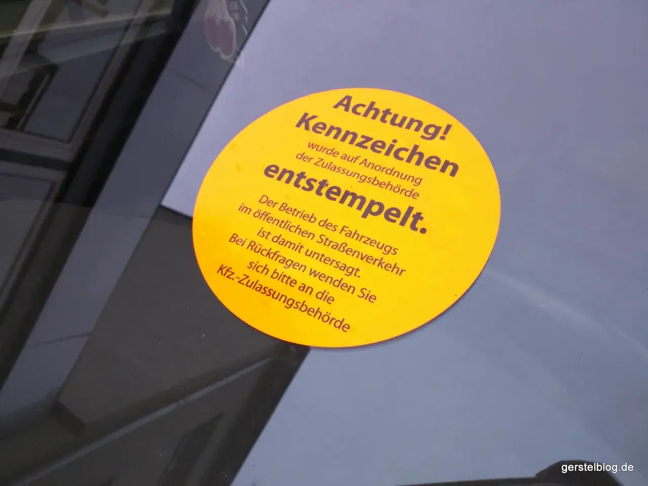Gelber Aufkleber auf einer Windschutzscheibe: