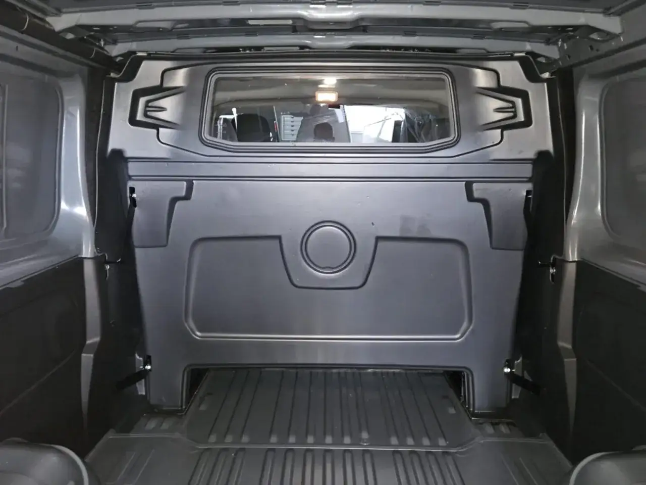 Die schwarze Trennwand mit Fenster im Laderaum eines Renault Trafic ist bereit f&uuml;r den Transport.