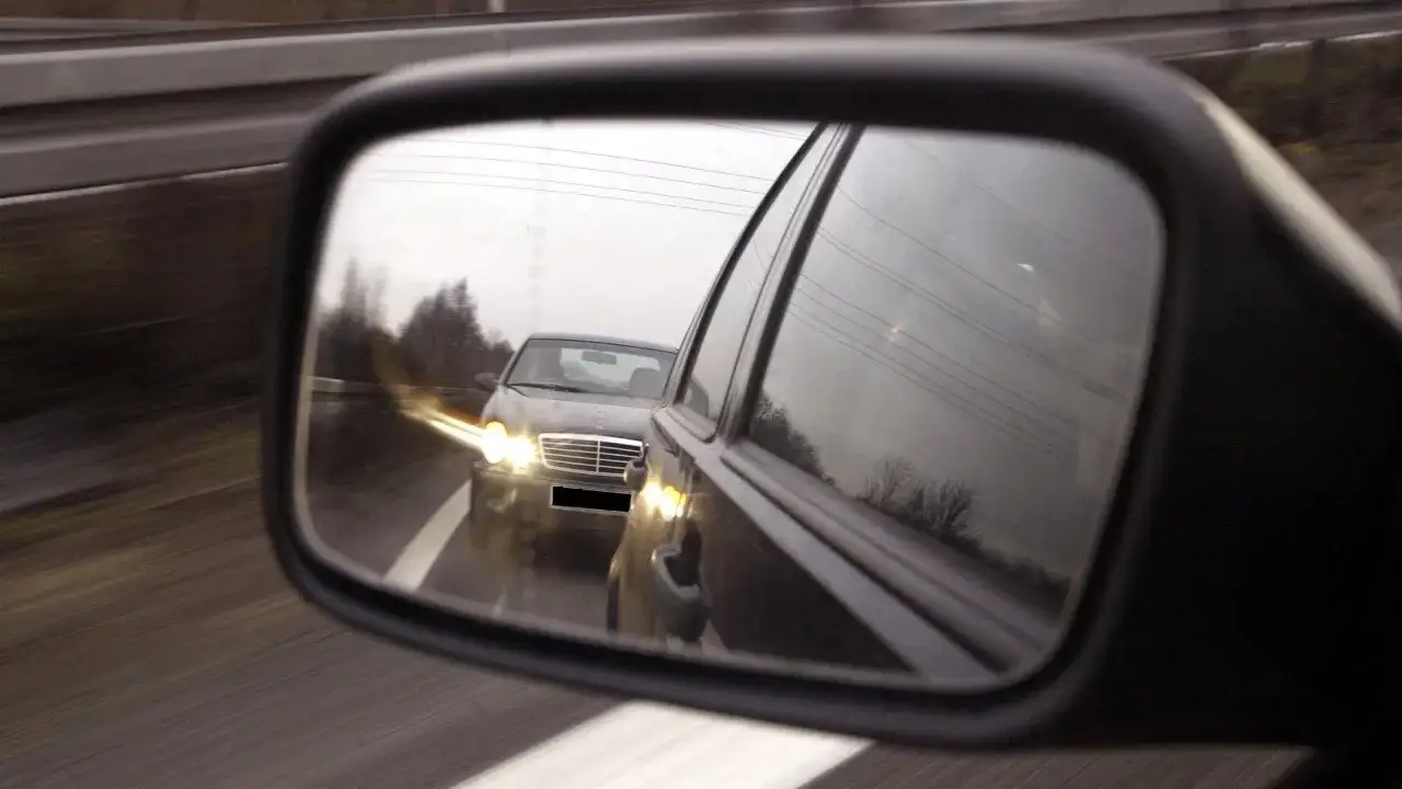 Ein Auto drängt auf der Autobahn. Die Lichthupe wird betätigt, um den Vordermann zu warnen.