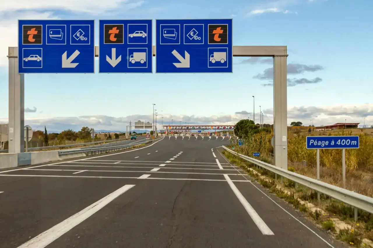 Maut Frankreich 2024: Schilder weisen den Weg zur Mautstation. Autos und LKWs werden getrennt.
