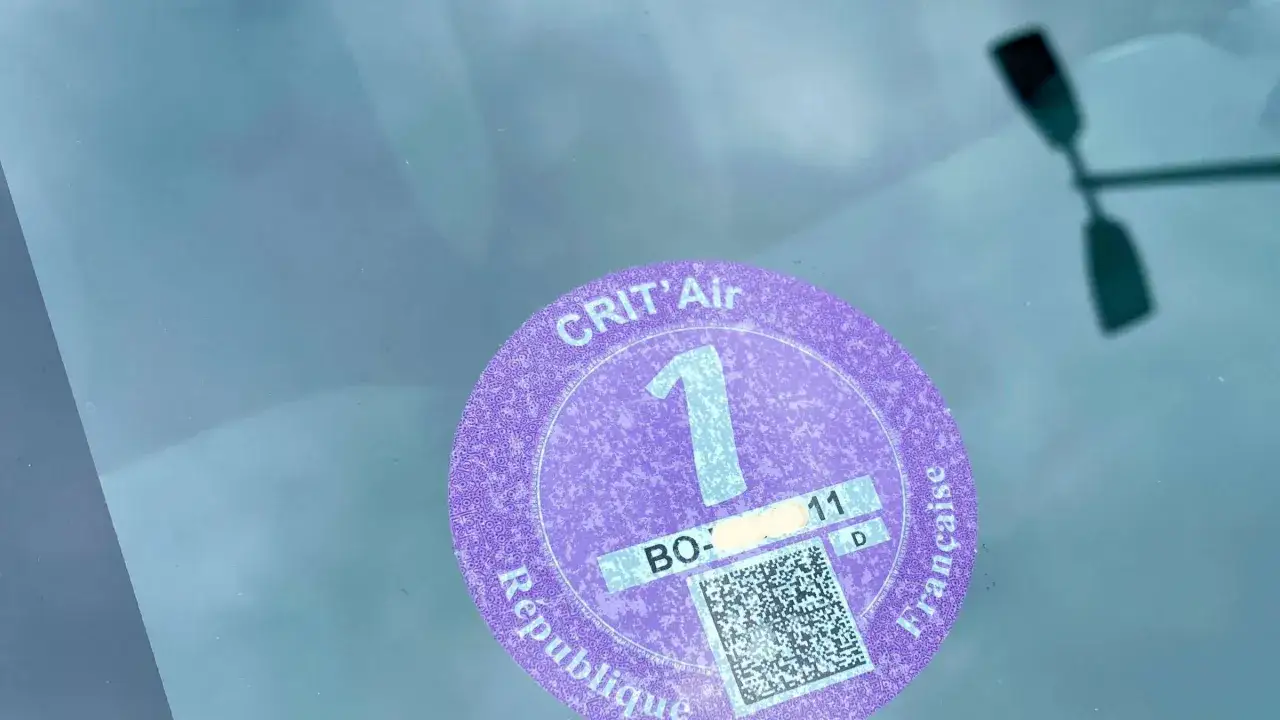 Eine Frankreich Vignette, die Crit'Air-Plakette Klasse 1, klebt an der Windschutzscheibe.