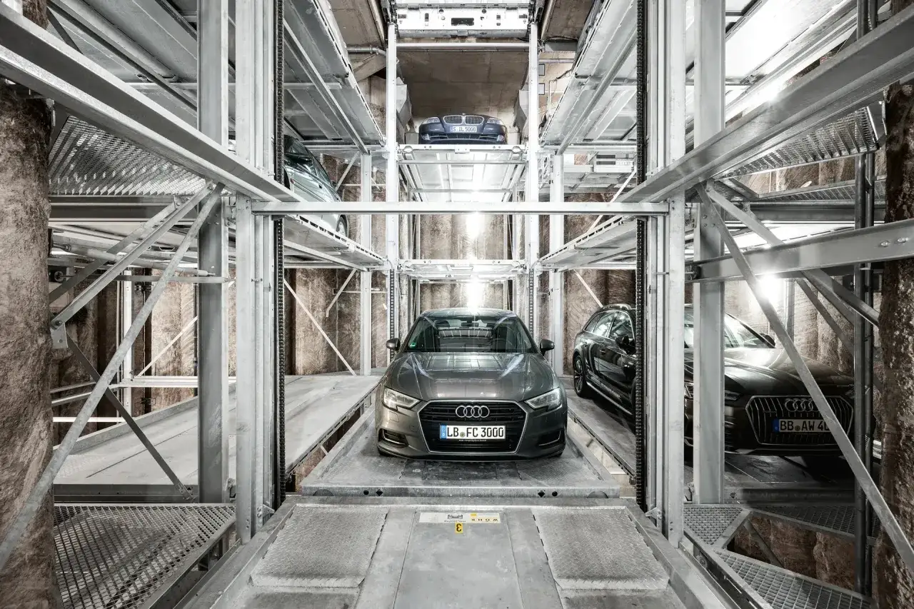 Mehrere breite Autos stehen in einem automatischen Parksystem auf verschiedenen Ebenen.
